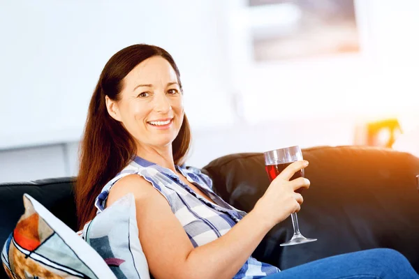 Donna con in mano un bicchiere di vino in casa — Foto Stock