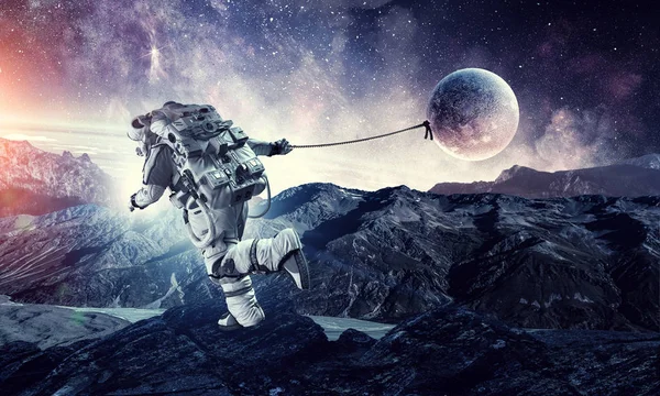 Fantasie afbeelding met spaceman vangst planeet. Mixed media — Stockfoto