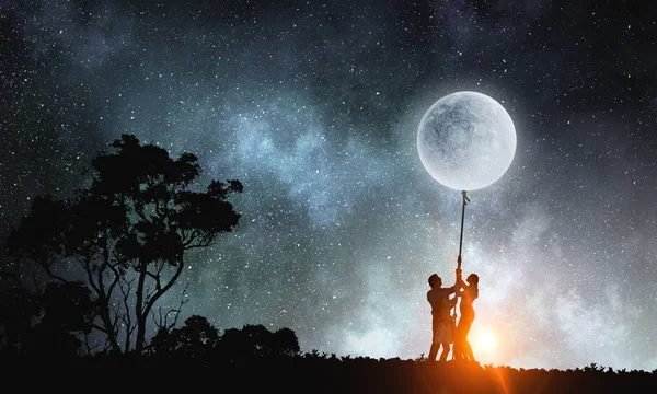 Människor fånga månen — Stockfoto