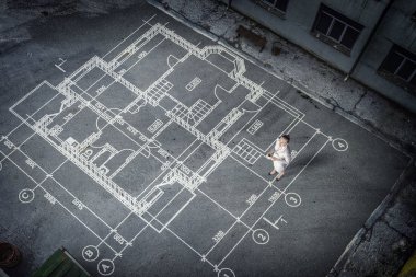 Kadın mühendis planı üzerinde düşünme. Karışık teknik