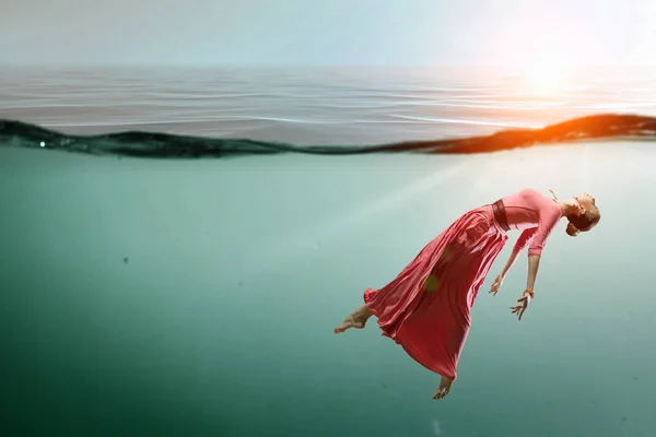 Vrouw danser in helder blauw water — Stockfoto