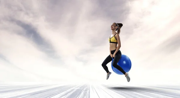 Sportig kvinna på fitness boll. Mixed media — Stockfoto