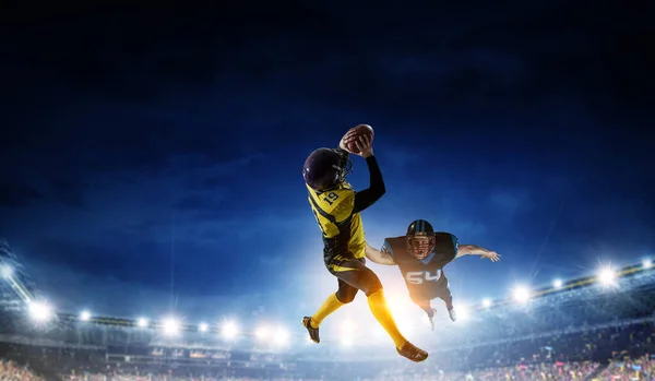 Jogadores de futebol americano lutam por bola. Meios mistos — Fotografia de Stock