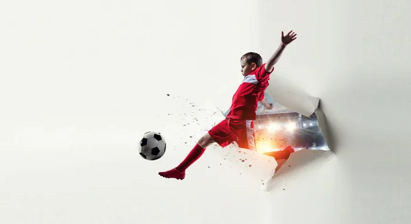 El futbolista chico rompiendo el papel blanco. Medios mixtos — Foto de Stock
