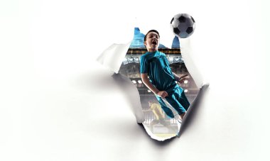 Çocuk futbolcu beyaz kağıtları kırıyor. Karışık ortam