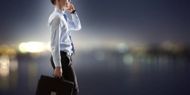 İş adamı cep telefonuyla konuşuyor. Karışık ortam