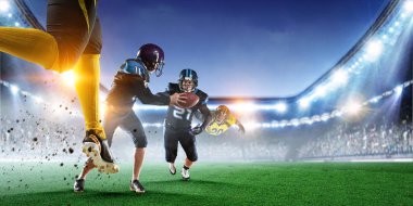 Amerikalı futbolcular top için savaşır. Karışık ortam