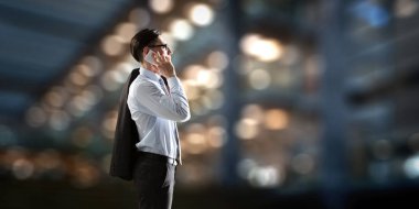 İş adamı cep telefonuyla konuşuyor. Karışık ortam