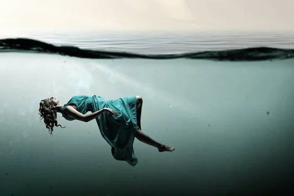 Woman dancer in clear blue water — Stock Photo, Image