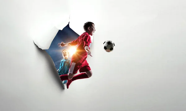 Детский футболист прорывается сквозь белую бумагу. Смешанные медиа — стоковое фото