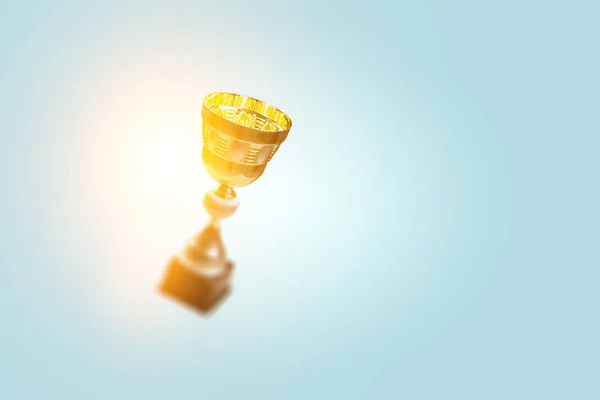 Golden cup on blue . Mixed media — Stock Photo, Image