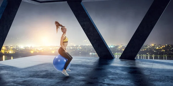 Sporty woman on fitness ball. Mixed media — Stock Photo, Image