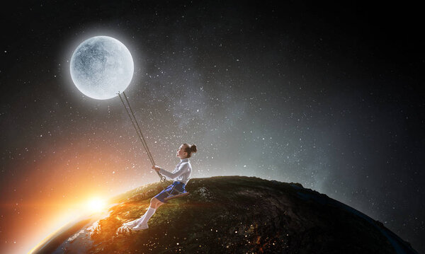 Cute little girl riding on swing. Elements of this image are furnished by NASA