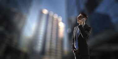 İş adamı cep telefonuyla konuşuyor. Karışık ortam