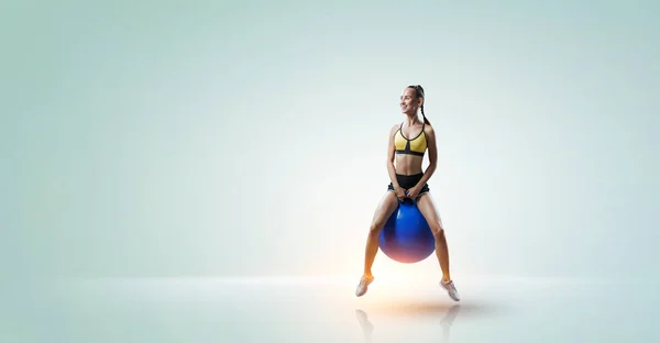 Femme sportive sur balle de fitness. Techniques mixtes — Photo