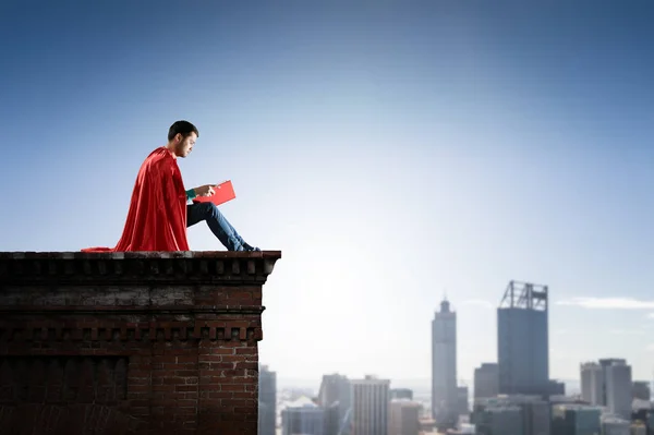 Super hero on roof. Mixed media — Stock Photo, Image