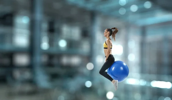 フィットネス ボールでスポーティな女性。ミクスト メディア — ストック写真