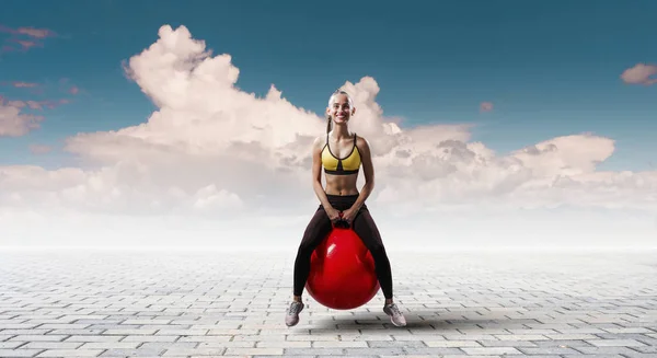 Sportieve vrouw op fitness bal. Mixed media — Stockfoto