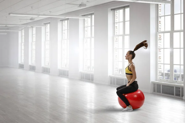 Sportliche Frau auf Fitnessball. Gemischte Medien — Stockfoto