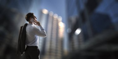 İş adamı cep telefonuyla konuşuyor. Karışık ortam