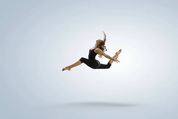 Gymnastka dívka ve skoku médií — Stock fotografie