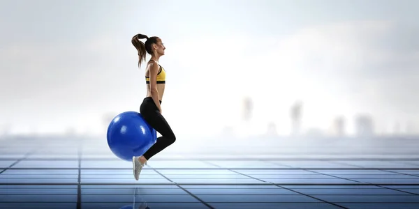 Mujer deportiva en la pelota de fitness. Medios mixtos —  Fotos de Stock