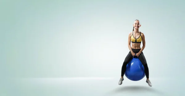 Sportliche Frau auf Fitnessball. Gemischte Medien — Stockfoto