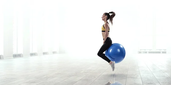 Sporty woman on fitness ball. Mixed media — Stock Photo, Image