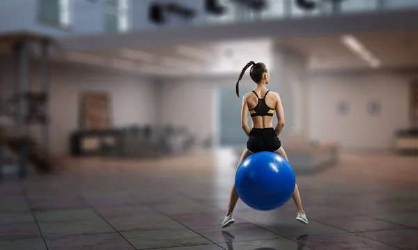 Sportliche Frau auf Fitnessball. Gemischte Medien — Stockfoto
