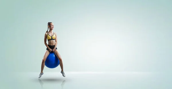 Mujer deportiva en la pelota de fitness. Medios mixtos —  Fotos de Stock