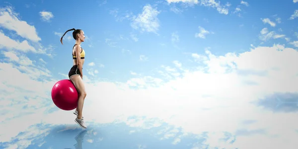 Sportliche Frau auf Fitnessball. Gemischte Medien — Stockfoto