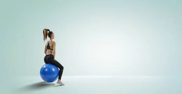 Sportliche Frau auf Fitnessball. Gemischte Medien — Stockfoto