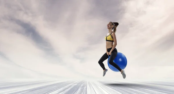 Sporty woman on fitness ball. Mixed media — Stock Photo, Image