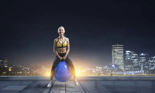 Sporty woman on fitness ball. Mixed media — Stock Photo, Image