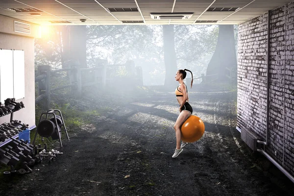 Sporty woman on fitness ball. Mixed media — Stock Photo, Image