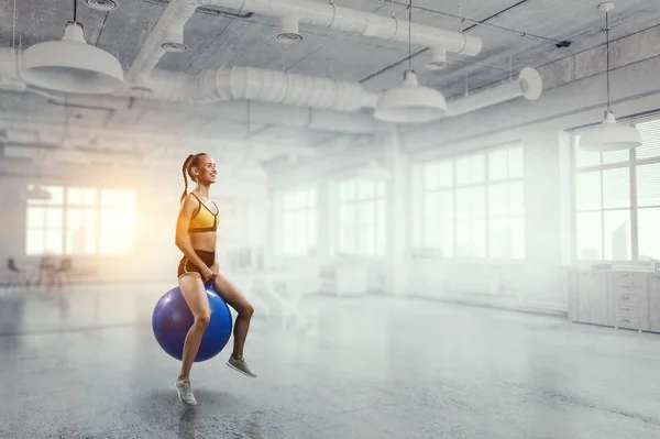 Sportliche Frau auf Fitnessball. Gemischte Medien — Stockfoto