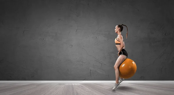 Sporty woman on fitness ball. Mixed media — Stock Photo, Image