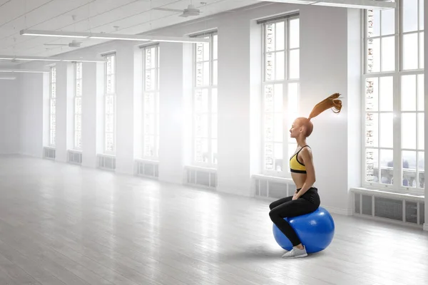 Sportliche Frau auf Fitnessball. Gemischte Medien — Stockfoto