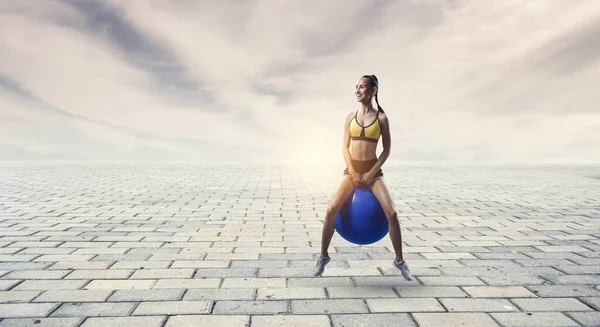 Sportliche Frau auf Fitnessball. Gemischte Medien — Stockfoto