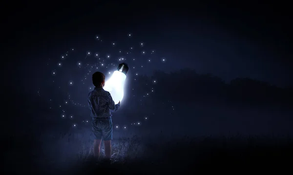 Pojke som håller en glödlampa — Stockfoto