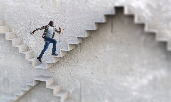 Черный бизнесмен поднимается по каменной лестнице, иллюстрируя развитие карьеры и концепцию успеха. Смешанные медиа