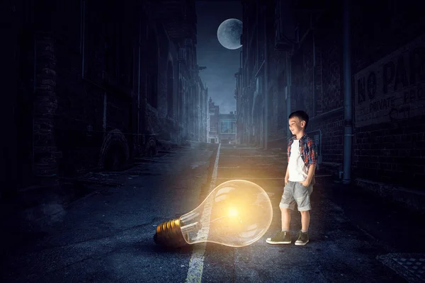 Rapaz segurando uma lâmpada — Fotografia de Stock