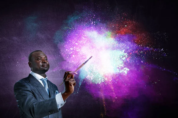 Konceptuell bild av ambitiös och kreativ affärsman i svart kostym håller pensel i handen — Stockfoto