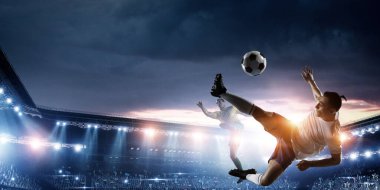 Futbol oyuncuları stadyumda hareket halindeler.
