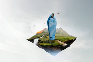 Uyku tulumundaki genç gezgin.
