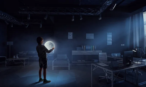 Garçon tenant la lune la nuit dans le bureau — Photo