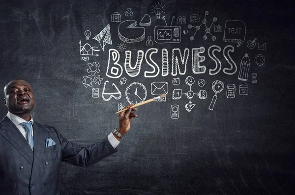 Концептуальный образ амбициозного и творческого бизнесмена в черном костюме, держащего кисть в руке — стоковое фото
