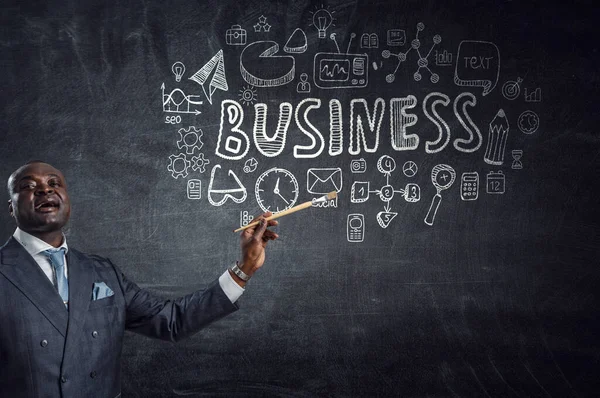 Conceptual image of ambitious and creative businessman in black suit holding paintbrush in hand — Stock Photo, Image