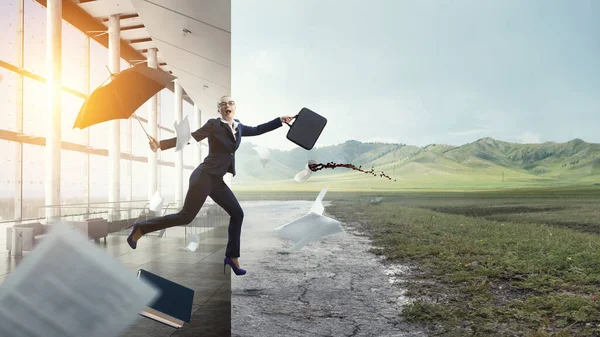 Jeune femme d'affaires marchant avec parapluie — Photo