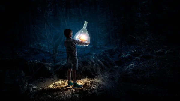 Boy holding glass flask with landscape inside it — Stock Photo, Image